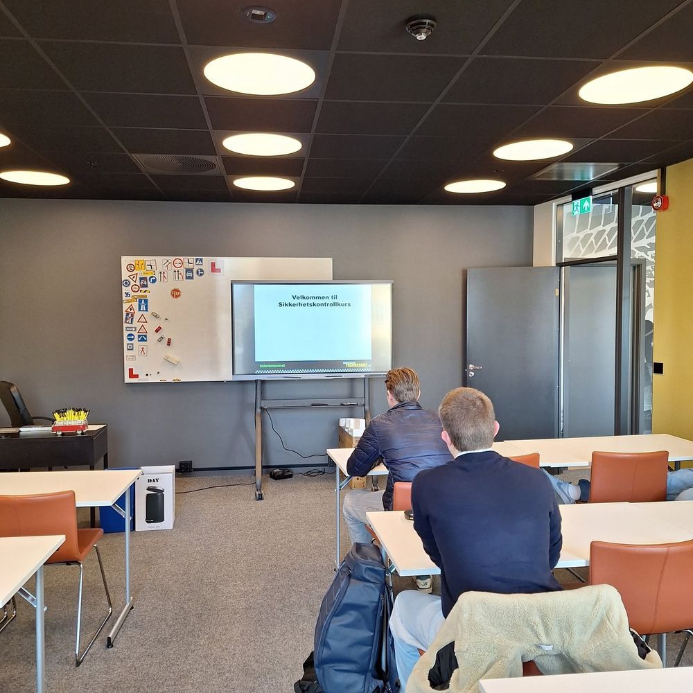 Teoriundervisning i klasserommet, med elever ved pultene og presentasjon på skjermen